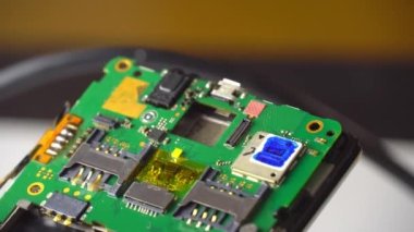 Telefonu tamir et. Teknisyen ya da usta akıllı telefon ana kart makrosunu inceliyor