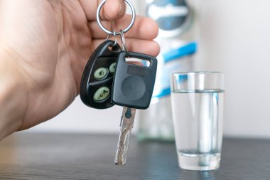 Adamın eli arabanın anahtarlarını alır ve arkaplandaki votkaya karşı kameraya gösterir. Sarhoş araba kullanma kavramı