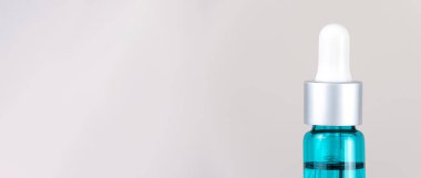 Yarım kozmetik turkuaz şişesi, beyaz arka planda göz damlası, fotokopi alanı, makro. Kozmetik kavramı, tıp. Pankart