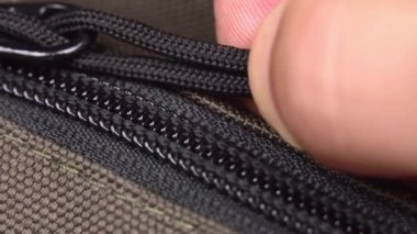 El fermuarı açar ve metal fermuarı bağlar. Yakın plan.