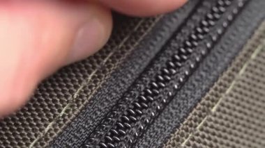 El fermuarı açar ve metal fermuarı bağlar. Yakın plan.