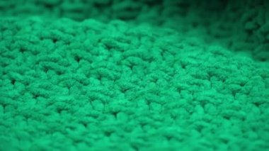 Süper yakın plan. Yeşil örülmüş yün kumaşın ayrıntıları. Tekstil arka planı. makro