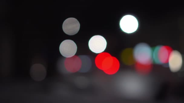 Mooie sprankelende bokeh op een donkere wazige achtergrond 's nachts. — Stockvideo