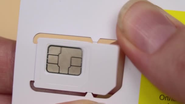 En kvinnas hand tar fram ett nytt SIM-kort från brickan — Stockvideo