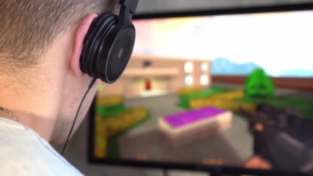 A gamer with headphones in the room is playing a video game. — Stock Video