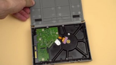 Erkeklerin elleri gri şok geçirmez çantayı açar ve 3.5 HDD 'yi çıkarır..,