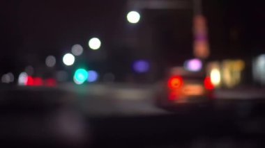Gece şehirde araba trafiği, arabanın içindeki kamera. Koyu bulanık arkaplanda bokeh