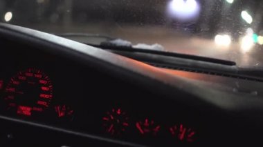 Bir adam bir gece şehrinin sokaklarında araba sürüyor. Gösterge panelini kapat.