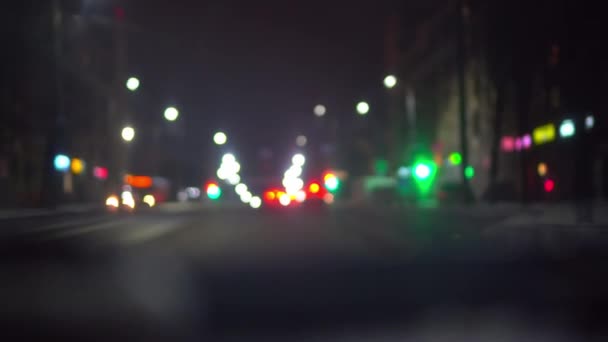 Tráfego de carro na cidade noturna, câmera dentro do carro. bokeh no fundo escuro embaçado — Vídeo de Stock