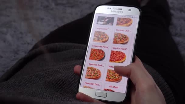 Una mujer pide comida en casa desde una tienda en línea, un teléfono inteligente — Vídeo de stock