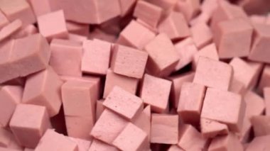 Kesme tahtasında dilimlenmiş haşlanmış sosis döner.