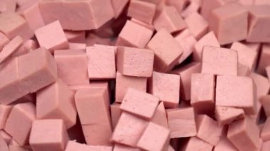 Kesme tahtasında dilimlenmiş haşlanmış sosis döner.