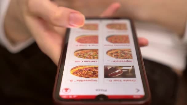 En kvinna beställer mat hemma från en webbutik, en smartphone — Stockvideo