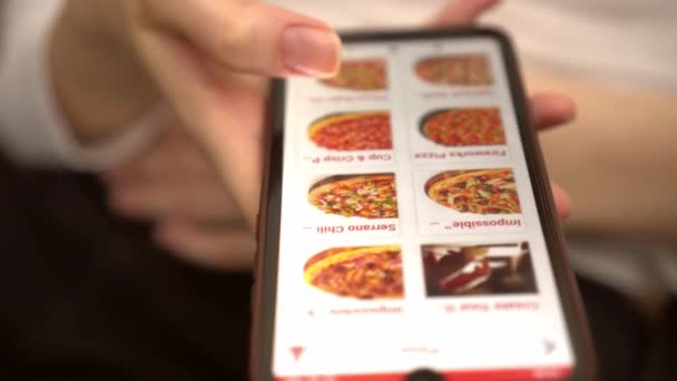 Una donna ordina cibo a casa da un negozio online, uno smartphone — Video Stock