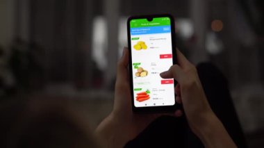 Bir kadın akıllı telefonunu kullanarak internetten yemek sipariş ediyor..
