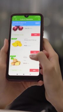 Bir kadın akıllı telefonunu kullanarak internetten yemek sipariş ediyor..