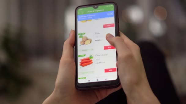 Een vrouw bestelt eten thuis in een online winkel met haar smartphone. — Stockvideo