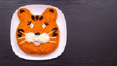 Havuç, yumurta, salatalık, patates, kuru erik ve sosisten yapılmış 2022 kaplan sembolü şeklinde komik bir salata. Yılbaşı yemeklerinin fotokopi odası. Tatil, yemek sanatı