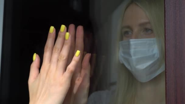 Two girls, sisters touch their hands with their palms through a glass window, — Stock Video