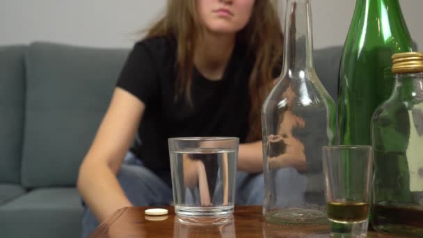 Frau leidet an Kater, sie wirft Schmerztablette in Wasserglas — Stockvideo