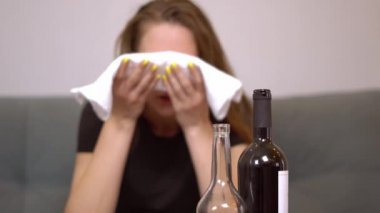 Akşamdan kalma bir kadın kafasına beyaz bir havlu koyar. Baş ağrısı.