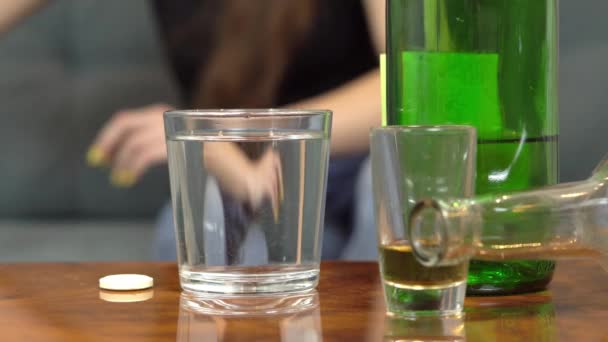 Kvinna lider av baksmälla, kastar hon smärtstillande piller i glas vatten — Stockvideo