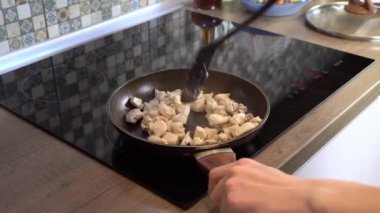 Tavuk fileto parçaları kızartma tavasında kızartılır. Kızarmış eti spatulayla karıştır..
