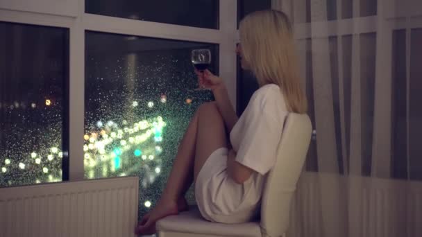 Na pozadí nočního města, žena drží sklenici vína. — Stock video