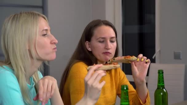 Mutfaktaki en mutlu iki kız arkadaş pizza yiyor ve bira içiyor.. — Stok video