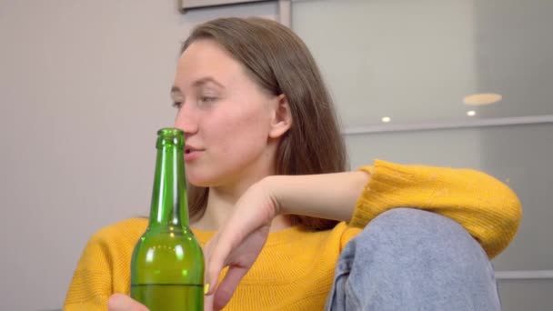 Két lány sört iszik és finom pizzát eszik otthon, a konyhájukban.. — Stock videók