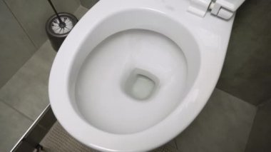 Sifonu çek. Su sifonu çeker. Seramik tuvaletteki suyu tuvalete atıp sifonu çekmek..