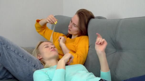Charming Eropa perempuan berbaring di sofa bodoh sekitar dan tertawa. — Stok Video