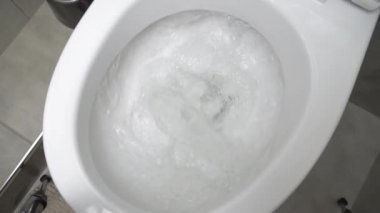Sifonu çek. Su sifonu çeker. Seramik tuvaletteki suyu tuvalete atıp sifonu çekmek..