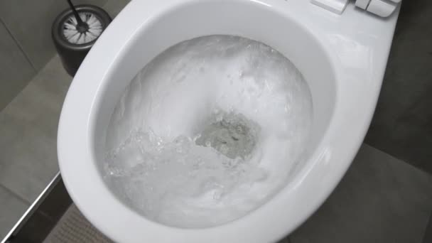 Sanita nivelada. A água despeja a sanita. Lavar a água no banheiro cerâmico. — Vídeo de Stock