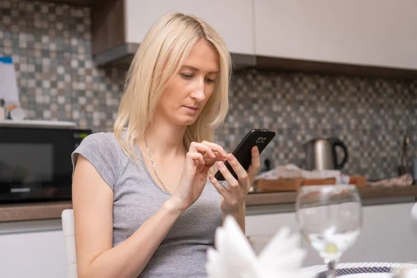 Giovane Bella Donna Siede Con Telefono Cellulare Nero Tra Mani — Foto Stock