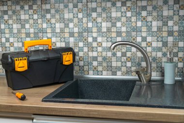 Mutfak lavabosu, modern bir mutfakta alet çantasıyla dolu. Tesisat onarım konsepti