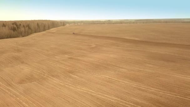Luftaufnahme eines landwirtschaftlichen Traktors, der ein Feld mit Dünger besprüht. — Stockvideo