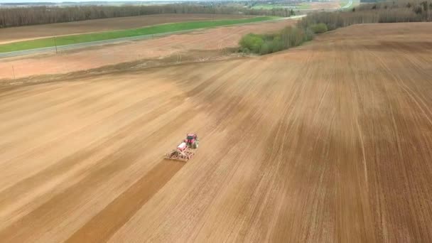 Sett fra luften på traktoren Klargjør et felt for planting, sett ovenfra – stockvideo