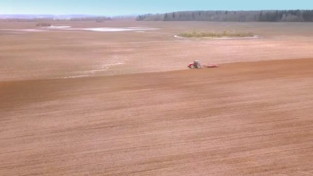 Sett fra luften på traktoren Klargjør et felt for planting, sett ovenfra – stockvideo