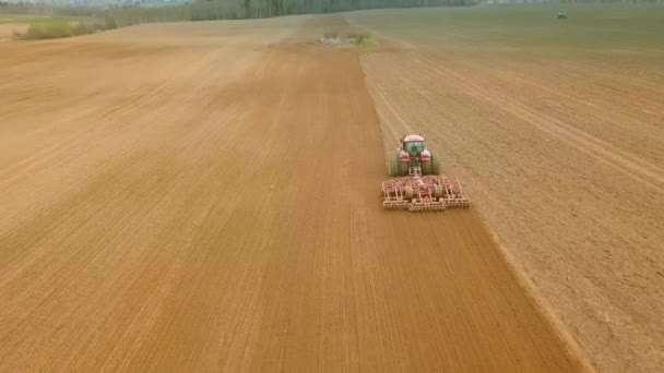 Sett fra luften på traktoren Klargjør et felt for planting, sett ovenfra – stockvideo