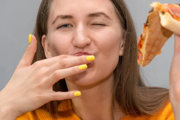 Zbliżenie Szczęśliwej Młodej Ciemnowłosej Kobiety Kawałkiem Pizzy Jednej Ręce Lizanie — Zdjęcie stockowe