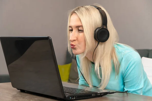 Młoda Piękna Blondynka Słuchawkami Patrzy Laptopa Dmucha Pocałunek Bliska — Zdjęcie stockowe