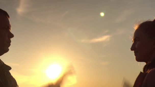 Een man en een vrouw high-five bij zonsondergang in een veld. Een close-up. slow motion — Stockvideo