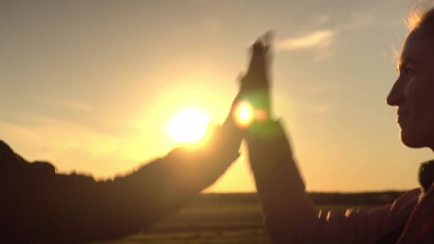 Las manos de chicas jóvenes dando chocos al atardecer. — Vídeos de Stock