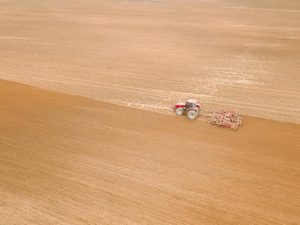 Roter Traktor Pflügt Einem Frühlingstag Saatgut Oder Dünger Aufs Feld — Stockfoto