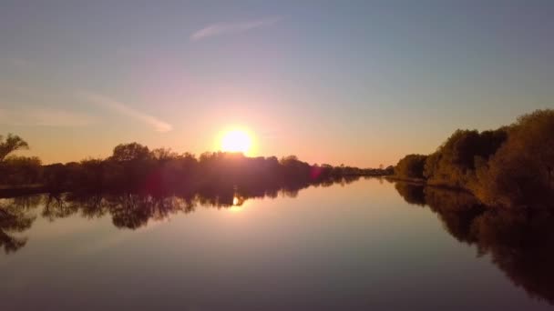 Беспилотник пролетает над красивым летним пейзажем с рекой на закате. — стоковое видео