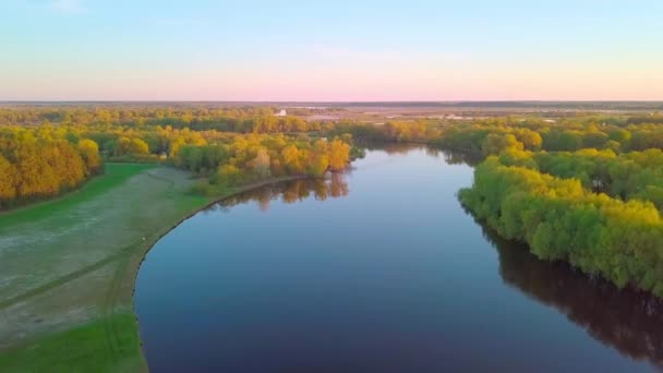 O drone voa sobre uma bela paisagem de verão com um rio ao pôr do sol. — Vídeo de Stock