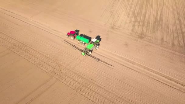 Een onbemand zicht op trekker met sproeier staat naast trekker met watertank — Stockvideo