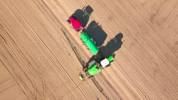 Sebuah pemandangan tak berawak traktor dengan penyemprot berdiri di samping traktor dengan tangki air — Stok Video