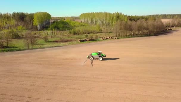 Trator pulverizando um campo com pulverizador, herbicidas e pesticidas ao pôr do sol. — Vídeo de Stock